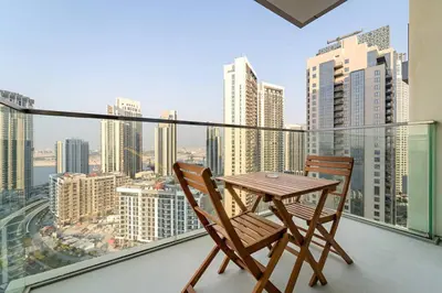 a table and two chairs on a balcony with a view at FIRST CLASS 1BR Urban Chic Oasis in Dubai