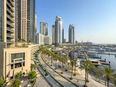 a city with tall buildings and a harbor with palm trees at FIRST CLASS 1BR Urban Chic Oasis in Dubai
