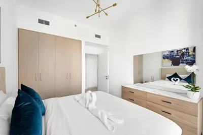 a bedroom with a large white bed with blue pillows at FIRST CLASS 1BR Urban Chic Oasis in Dubai