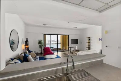 a kitchen with a sink and a living room at Full Sea View - Spacious & Newly Renovated Studio in JBR in Dubai