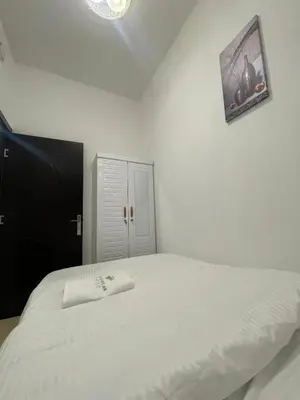 a bedroom with a white bed with a picture on the wall at Four Stars Dubai Marina JBR in Dubai Marina