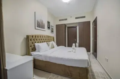 a bedroom with a bed with a cat sitting on it at 2BR - LUXE Serene Suite by Canal in Dubai