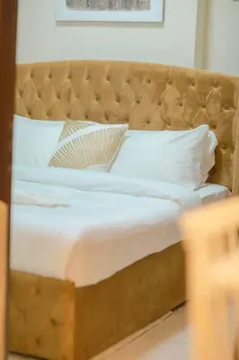 a bed with white sheets and pillows in a room at 2BR - LUXE Serene Suite by Canal in Dubai