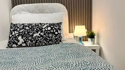 a bed with a black and white pillow and a lamp at Atelier Partition Room in Tecom Near Internet City Metro in Dubai