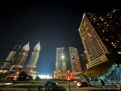 a city skyline at night with tall buildings at Metropolis View Partition Room Near Internet City Metro in Dubai