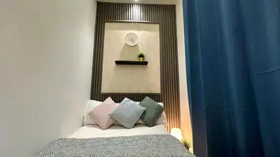 a bedroom with a bed with pillows and a clock at Horizon View Partition Room in Barsha Heights Near Metro in Dubai