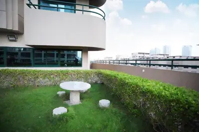 a white table in the grass in front of a building at Horizon View Partition Room in Barsha Heights Near Metro in Dubai