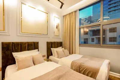 two beds in a room with a window at Elite Waterfront 3BR Haven - Marina and Sea Views! in Dubai