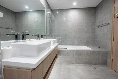 a bathroom with a large white sink and a tub at Top-Notch 3BR in Stella Maris Tower in Dubai Marina in Dubai