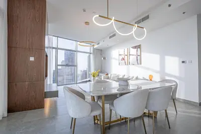 a dining room with a white table and chairs at Top-Notch 3BR in Stella Maris Tower in Dubai Marina in Dubai