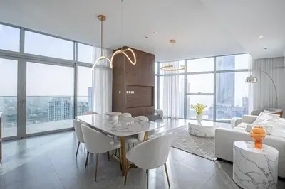 a dining room and living room with a table and chairs at Top-Notch 3BR in Stella Maris Tower in Dubai Marina in Dubai