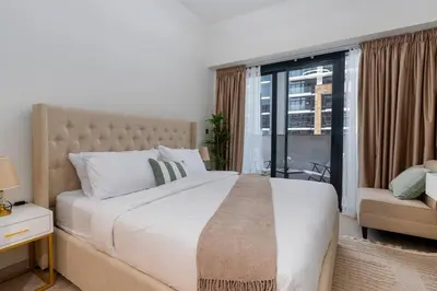 a bedroom with a large white bed and a window at Cozy Studio in Azizi Riviera - Dubai in Dubai