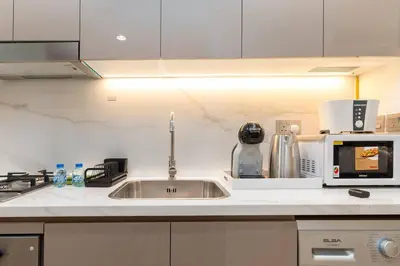a kitchen with a sink and a microwave at Cozy Studio in Azizi Riviera - Dubai in Dubai