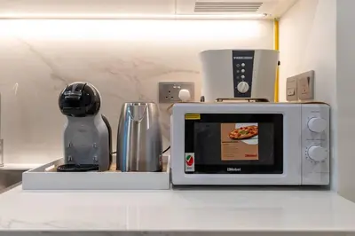 a kitchen counter with a microwave and a blender at Cozy Studio in Azizi Riviera - Dubai in Dubai