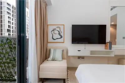 a hotel room with a bed and a tv at Cozy Studio in Azizi Riviera - Dubai in Dubai