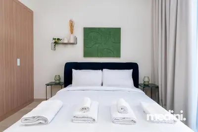 a bedroom with a bed with two towels on it at Cozy Studio in Azizi Riviera - Dubai in Dubai