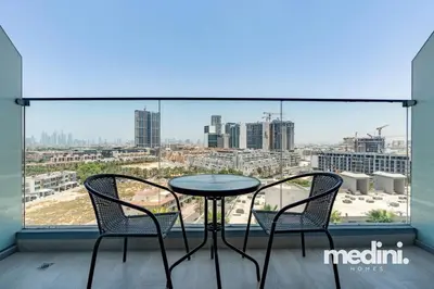 a table and two chairs on a balcony with a view at Studio in Bloom Height - JVC - Dubai in Dubai