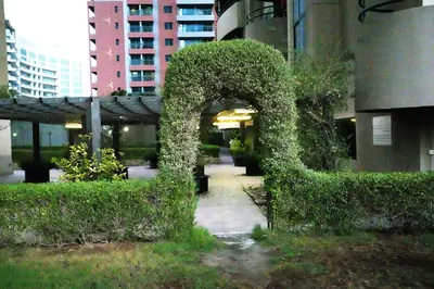 an arch covered in ivy next to a building at Wanderlust Partiton Room in Tecom Near Internet City Metro in Dubai