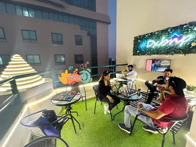 a group of people sitting at tables on a balcony at Wanderlust Partiton Room in Tecom Near Internet City Metro in Dubai