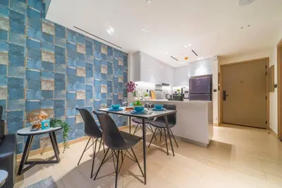 a kitchen and dining room with a table and chairs at Serene 1BR Haven with Pool View in Binghatti Corner! in Dubai