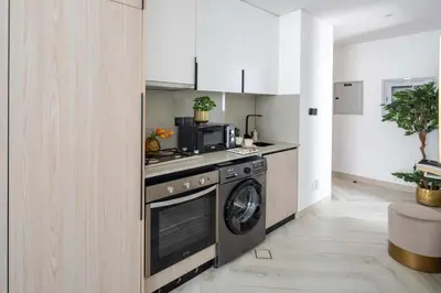 a kitchen with a stove and a washing machine at Frank Porter - Empire Residences in Dubai