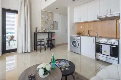 a kitchen and living room with a table in it at Frank Porter - Square Tower in Dubai