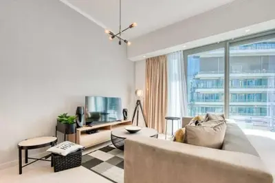 a living room with a couch and a tv at Bright & Serene Flat in the Marina, by Only Stays in Dubai