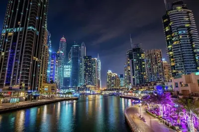 a city skyline at night with a river and buildings at Bright & Serene Flat in the Marina, by Only Stays in Dubai