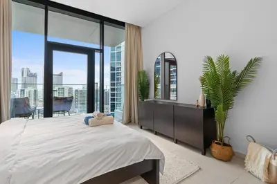 a bedroom with a large bed and a large window at Waves - Chic High-Floor Studio Retreat with Canal Views in Dubai