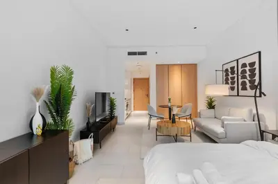 a bedroom with a bed and a living room at Waves - Chic High-Floor Studio Retreat with Canal Views in Dubai