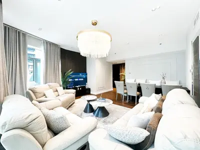 a living room with white furniture and a dining room at 3-BDR Marina Gem w Stunning Yacht Bay Views in Dubai