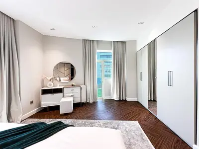 a bedroom with white walls and a mirror and a bed at 3-BDR Marina Gem w Stunning Yacht Bay Views in Dubai