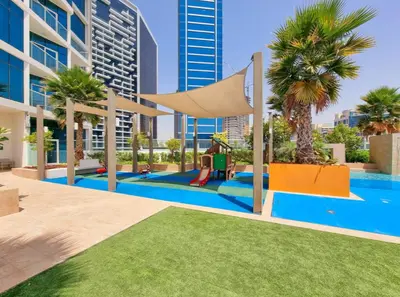 a pool with a hammock and palm trees in a building at Royalton - Damac Maison Prive in Dubai