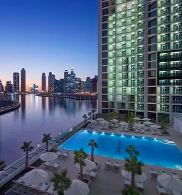 a view of a large building with a swimming pool at Royalton - Damac Maison Prive in Dubai