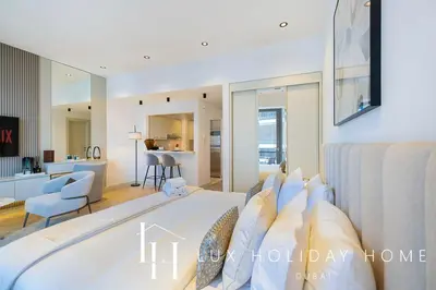a bedroom with a large bed and a living room at LUX The Silverene Marina View Studio 1 in Dubai