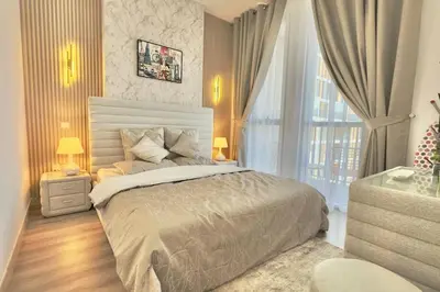 a bedroom with a large bed and a large window at Elegant 1BR Midtown Near City Center Meaisem by Vibel in Dubai