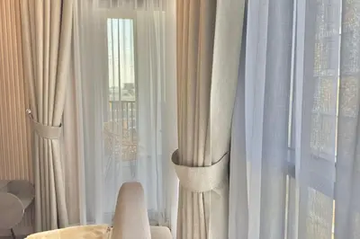 a room with white curtains and a window at Elegant 1BR Midtown Near City Center Meaisem by Vibel in Dubai