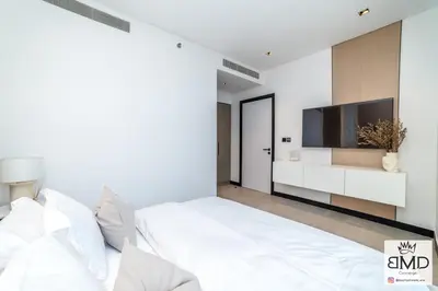 a white bedroom with a large bed and a flat screen tv at Mordern Burj khalifa View 2bd in Dubai