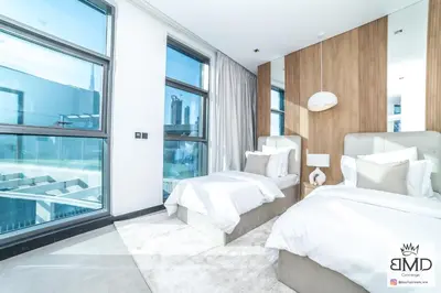 two beds in a bedroom with a window at Mordern Burj khalifa View 2bd in Dubai