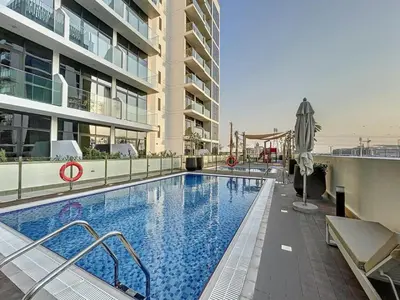 a large swimming pool in front of a building at Azizi Riviera 29 - Aesthetic Studio in Meydan in Dubai