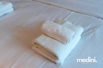 two towels sitting on top of a bed at Studio One - Dubai Marina - Pool, Sauna, Hammam and Gym in Dubai