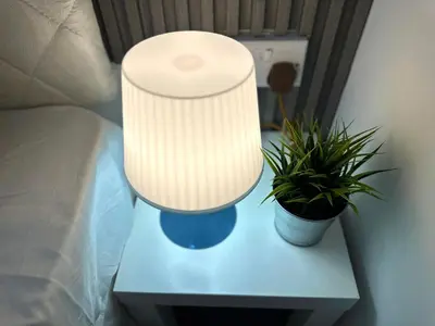 a lamp on a table next to a bed at Radiant Parition Room in Barsha Heights Near Metro in Dubai