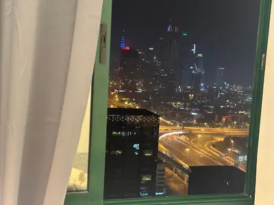a view of a city at night from a window at Explorer Partition Room with window Near Internet City in Dubai