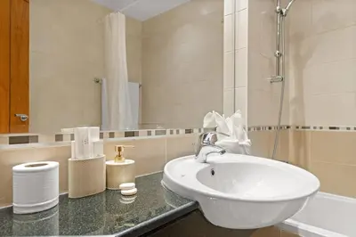 a bathroom with a white sink and a mirror at FIRST CLASS 2BR Luxurious Escape in Dubai