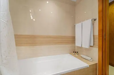 a bathroom with a white tub and a white towel at FIRST CLASS 2BR Luxurious Escape in Dubai