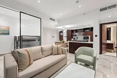 a living room with a couch and a kitchen at FIRST CLASS 2BR Premium City Escape in Dubai