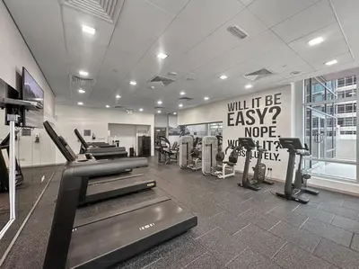 a gym with treadmills and machines in a room at FIRST CLASS 2BR Premium City Escape in Dubai