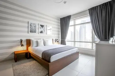 a bedroom with a bed and a large window at Blueground Downtown BK view pool gym DXB-130 in Dubai