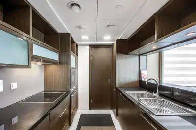 a kitchen with wooden cabinets and stainless steel appliances at Blueground Downtown BK view pool gym DXB-130 in Dubai