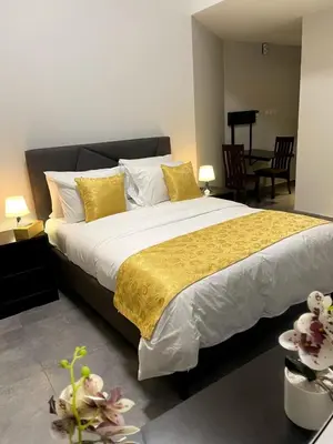 a bedroom with a large bed with a yellow blanket at Ista Vacation Homes LLC in Dubai